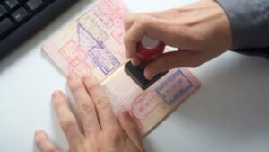Person stamping passport with official visa approval stamp