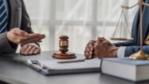 Lawyers discussing case over legal documents with gavel on desk